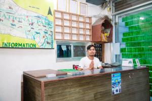 a man sitting at a counter in a restaurant at Hotel Shiva's Dream in Sauraha +37 photos