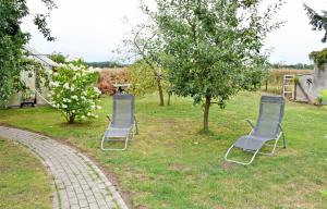 two chairs sitting in the grass in a yard at Ferienhaus Falkenhagen mit Garten in Pachthof