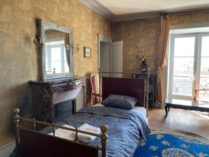 a bedroom with a bed and a mirror on the wall at Chambre pour 3 personnes au Chateau in Blet