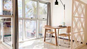ブエノスアイレスにあるFeel Buenos Aires Apartmentsのテーブルと椅子、窓が備わる客室です。