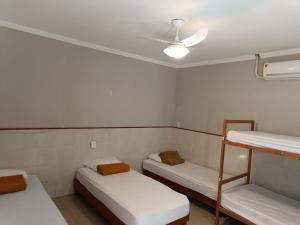 a room with two beds and a ceiling fan at Hostel Diniz in Vitória