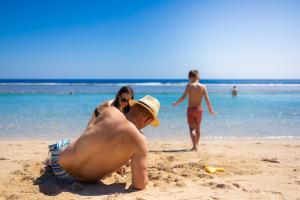 Akassia Swiss Resort في القصير: رجل يستلقي في الرمال على الشاطئ
