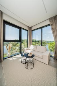カウナスにあるKaunorama Riverside Suiteのリビングルーム(白いソファ、大きな窓付)