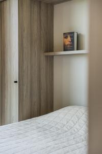een slaapkamer met een bed en een boek op een plank bij Kaunorama Riverside Suite in Kaunas