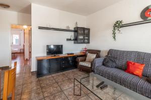 een woonkamer met een bank en een tv bij Carboneras 54 Apartamento acogedor cerca del mar in Girona