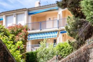 um edifício de apartamentos com varandas e arbustos em Carboneras 54 Apartamento acogedor cerca del mar em Girona