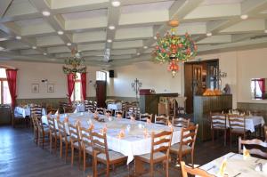 a dining room with tables and chairs and a chandelier at Berghotel Pöhlberg in Annaberg-Buchholz