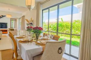 a dining room with a table and a large window at Kuza The Palm Villas at Vipingo in Kilifi