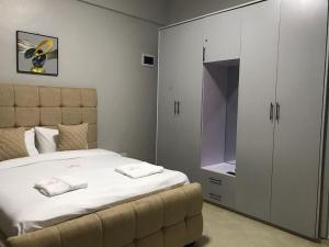 a bedroom with a bed and a large white cabinet at JnB Naivasha town 1Bedroom in Naivasha