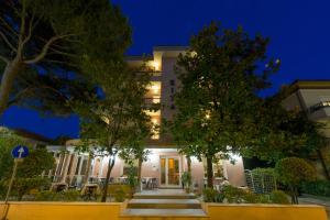 a building with trees in front of it at night at Hotel Rita in Riccione