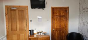 una stanza con una porta e una televisione sul muro di Armadale Guest House a Inverness