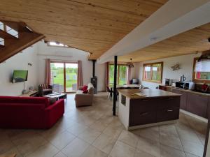 a large kitchen and living room with a red couch at Gite entre Loire, châteaux et Sologne in Saint-Claude-de-Diray
