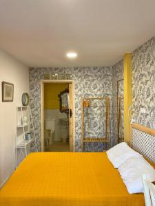 1 Schlafzimmer mit einem orangenen Bett und einem Badezimmer in der Unterkunft Habitaciones Estrella del Norte in Santander