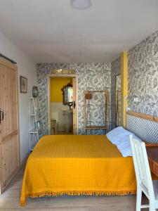 ein Schlafzimmer mit einem Bett und einer gelben Tagesdecke in der Unterkunft Habitaciones Estrella del Norte in Santander