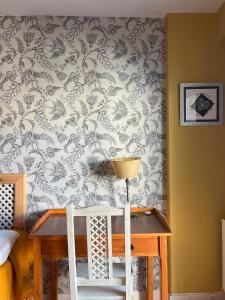 Pokój ze stołem i ścianą z tapetą w obiekcie Habitaciones Estrella del Norte w mieście Santander