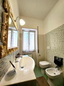 a bathroom with a sink and a toilet and a mirror at Appartamento comodo e accogliente a Ciampino in Ciampino