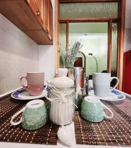 a kitchen counter with cups and plates and a mirror at Appartamento comodo e accogliente a Ciampino in Ciampino