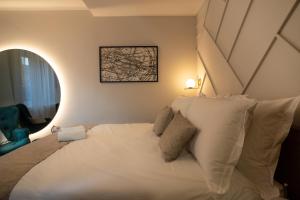 een slaapkamer met een groot wit bed met kussens bij Apartments and More in Zagreb