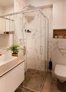 een badkamer met een glazen douche en een toilet bij Apartments and More in Zagreb