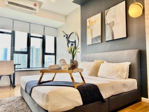 Un dormitorio con una cama con una mesa. en Infinity Pool Ceylonz Suites KLCC en Kuala Lumpur