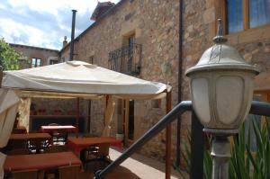 een witte paraplu en een aantal tafels en stoelen en een straatlicht bij HOTEL RURAL EL DENARIO in Garray