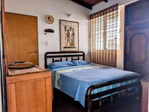 a bedroom with a blue bed and a wooden cabinet at Casa Acogedora y Encantadora in San Cristóbal