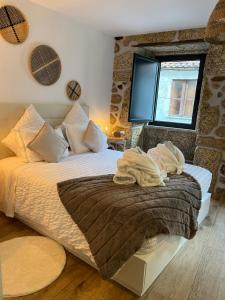 Schlafzimmer mit einem Bett mit weißer Bettwäsche und einem Fenster in der Unterkunft Senhora da Estrela AL in Seia