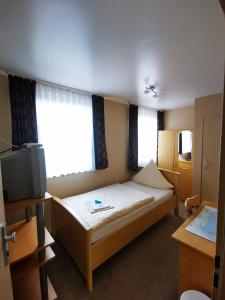 a hotel room with a bed and a television at Hotel Art Balkanhof in Gelsenkirchen