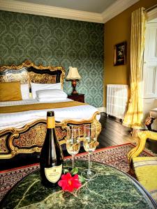 um quarto com uma cama com uma garrafa de vinho e dois copos em Clone Country House em Aughrim