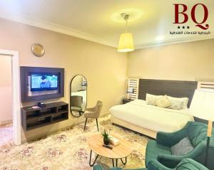 البندقية للخدمات الفندقية BQ HOTEL SUITES في بريدة: غرفة نوم بسرير وتلفزيون وأريكة