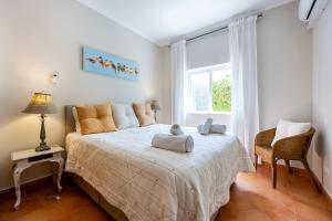 een slaapkamer met een bed met twee handdoeken erop bij CoolHouses Algarve, Casa das Amendoeiras, V4 Praia da Luz in Luz
