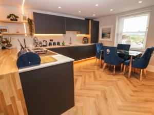 a kitchen with black cabinets and a table and chairs at Netherdale Penthouse in Buxton