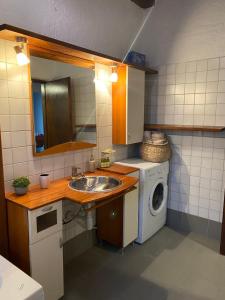 a small kitchen with a sink and a washing machine at Two Olives in Vrbnik