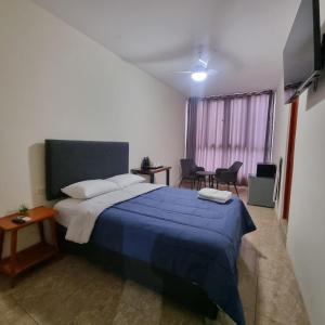 a bedroom with a bed with a blue blanket at Gran Imperial Avenida in Tumbes