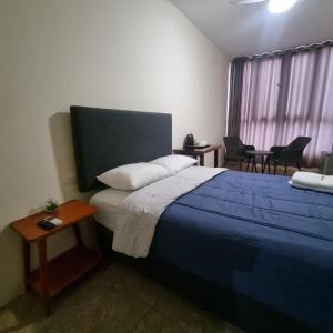 a bedroom with a bed and a table and chairs at Gran Imperial Avenida in Tumbes