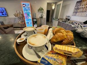 a tray of food with coffee and pastries on a table at Hotel Clinton in Casoria