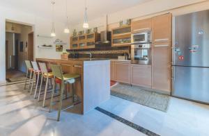 una cocina con electrodomésticos de acero inoxidable y armarios de madera en Saint George Apartment, en Preveza