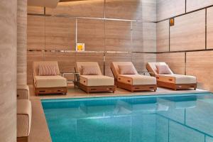 a pool with lounge chairs and a swimming pool at The Emory in London