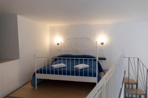 una piccola camera da letto con un letto con lenzuola blu di PALAZZO PELLEGRINO vietri a Vietri