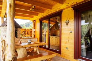 eine Blockhütte mit einem Holztisch und einem Fenster in der Unterkunft Lake Cottage - Koča ob jezeru in Nazarje