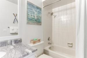 a white bathroom with a tub and a sink at Beaver Lake Retreat with Deck Paddle, Bike, Relax! in Springdale +28 photos