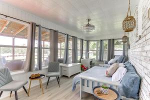 a living room with a bed and chairs and windows at Beaver Lake Retreat with Deck Paddle, Bike, Relax! in Springdale