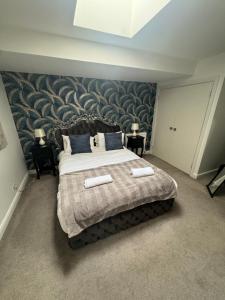 una camera con un grande letto con una parete a motivi geometrici di The Capon Tree Town House a Jedburgh