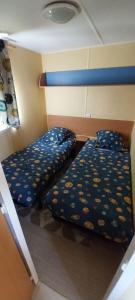 ein kleines Schlafzimmer mit 2 Betten in einem Zimmer in der Unterkunft Chez Elvis et Agnès 