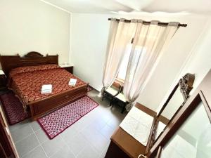 a small bedroom with a bed and a window at Mare e Montagna in Bonarcado