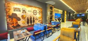 バクーにあるAriva Center Hotelの青と黄色の椅子と壁のあるレストラン