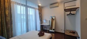 1 dormitorio con cama, espejo y ventana en My Misto Homestay, Riverson Soho en Kota Kinabalu