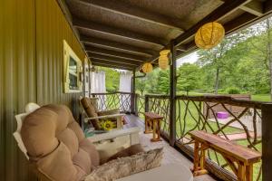 un porche cubierto con una silla y una mesa en Kentucky Mtn Home on 80 Acres with Hot Tub and Trails!, 