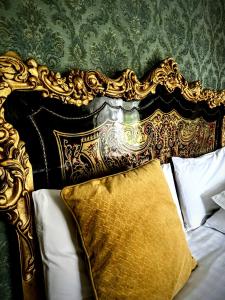 ein goldenes und schwarzes Kopfteil eines Bettes mit einem Kissen in der Unterkunft Clone Country House in Aughrim