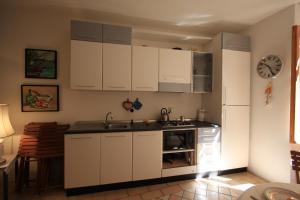 a kitchen with white cabinets and a sink at Fisherman's House in Riomaggiore